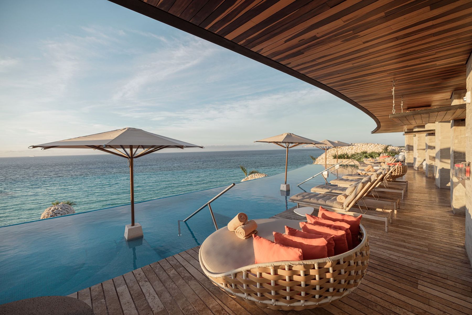 A rooftop lounge with a hanging chair above the Caribbean Sea