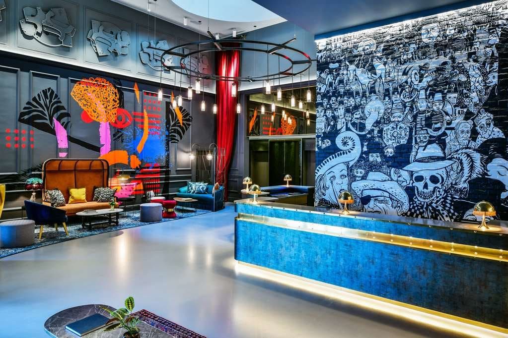 The lobby, with bold murals and a blue reception desk
