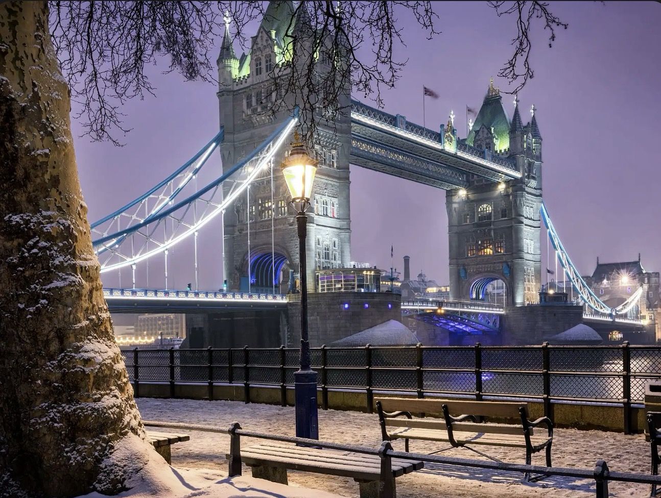 Tower Bridge lit up on a snowy evening