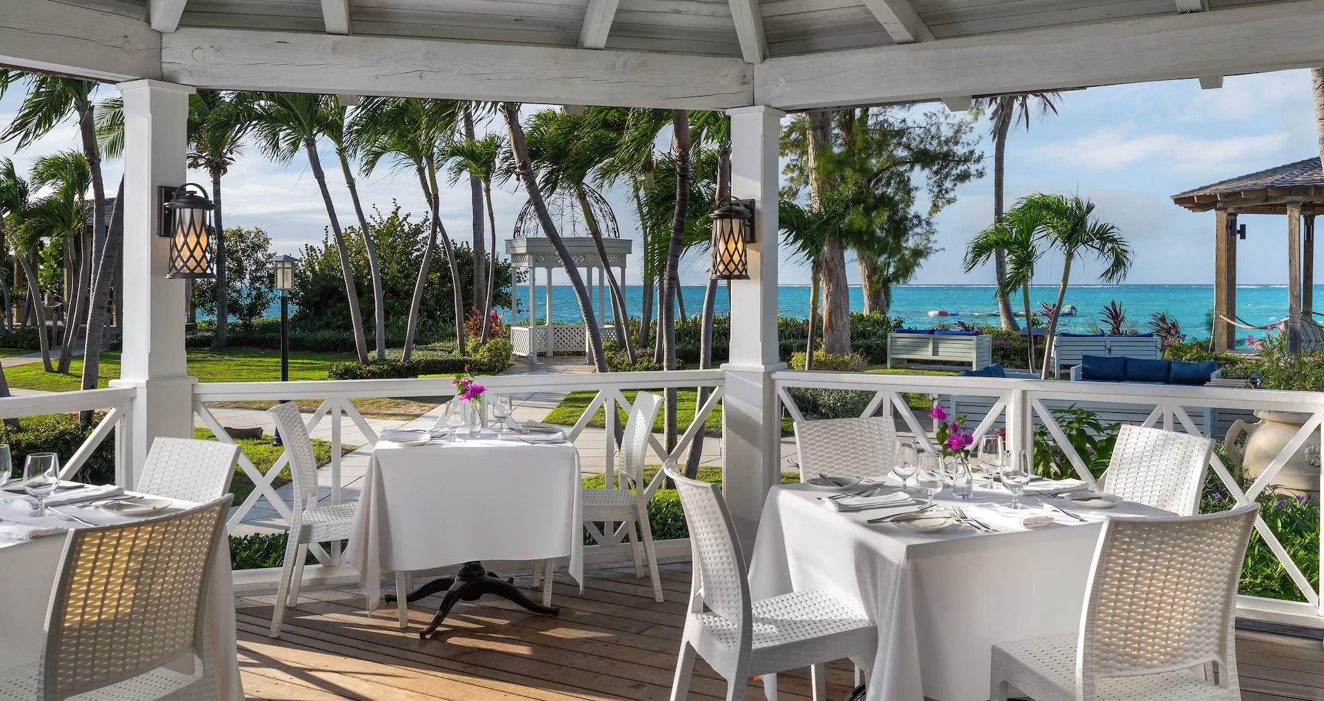 A white gazebo set for dinner by the beach in Turks & Caicos