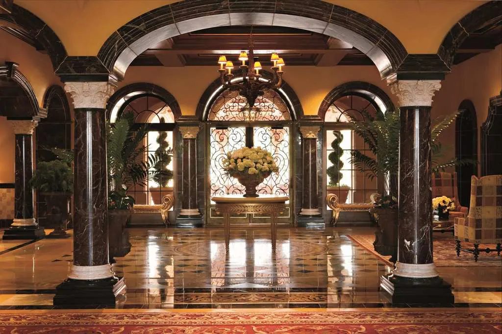 The lobby's marble columns and arches around a central arrangement of flowers