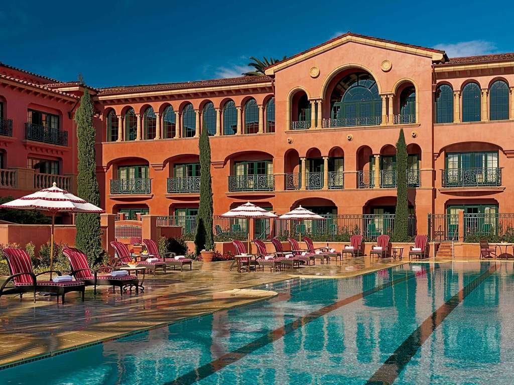 The main pool and striped umbrellas before the resort's terracotta facade