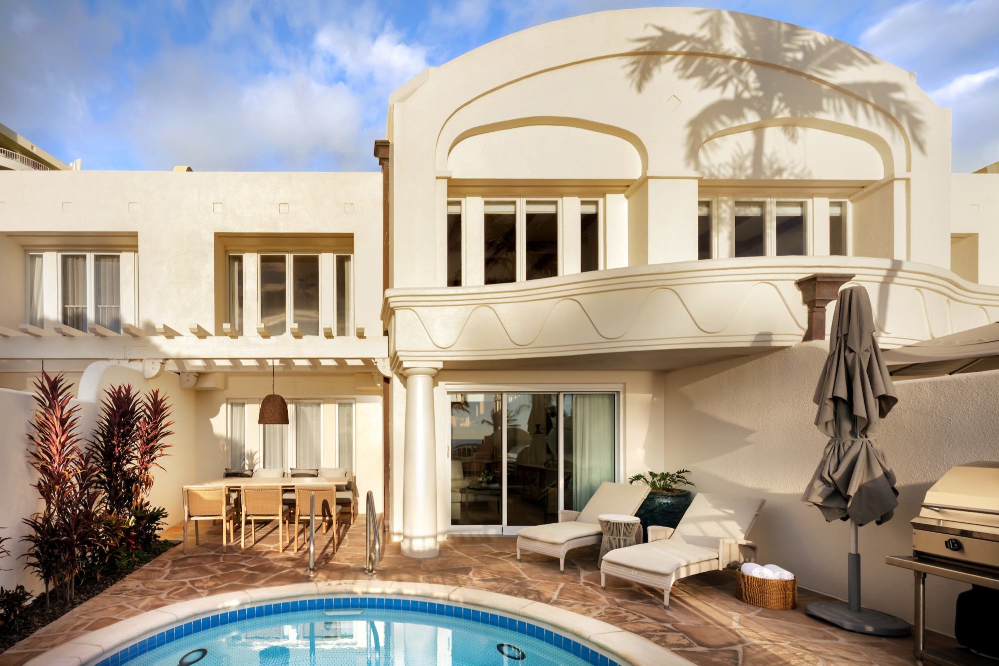 A two-story villa courtyard with a private plunge pool, loungers, and a barbecue grill