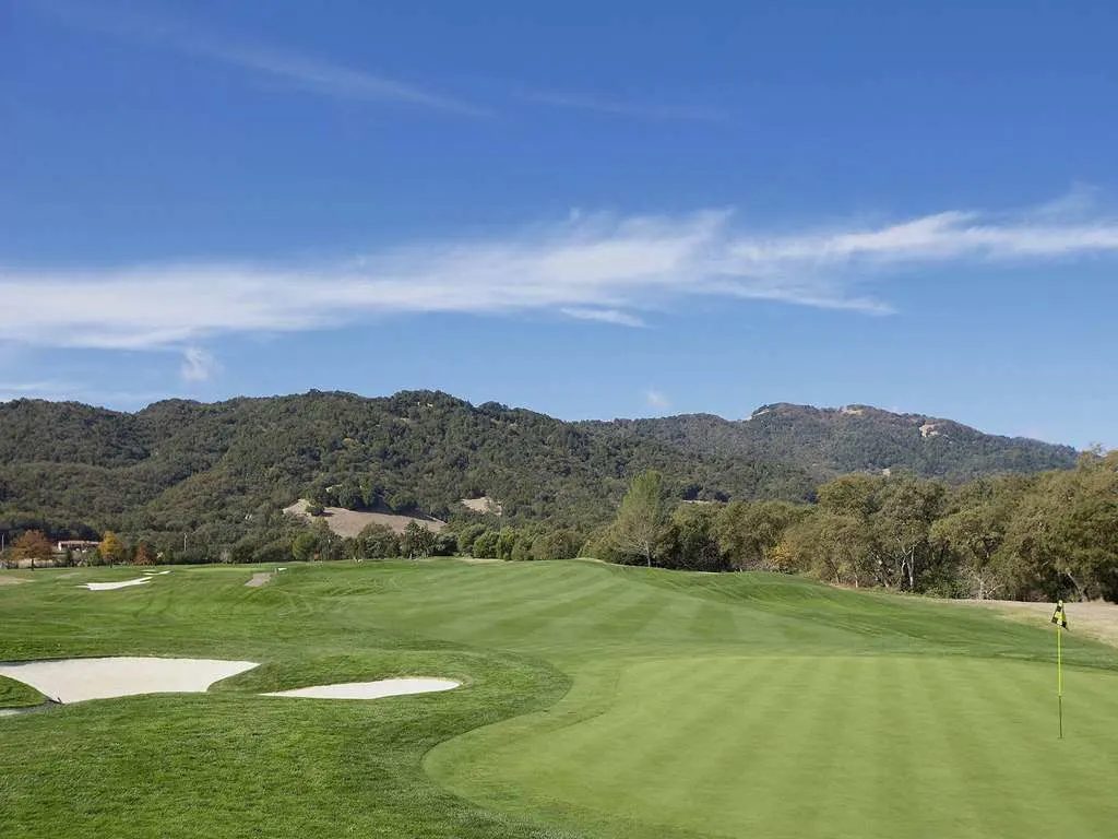 A golf green with bunkers beneath the hills of Sonoma Valley