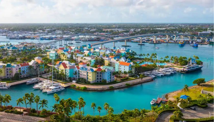 A colorful Caribbean harbor town with turquoise water and marinas