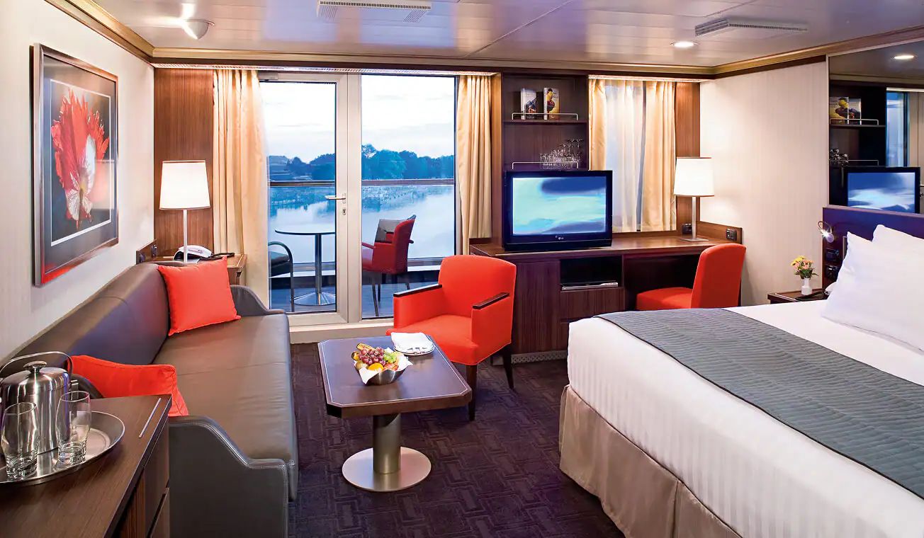 A verandah stateroom with a sitting area and balcony doors