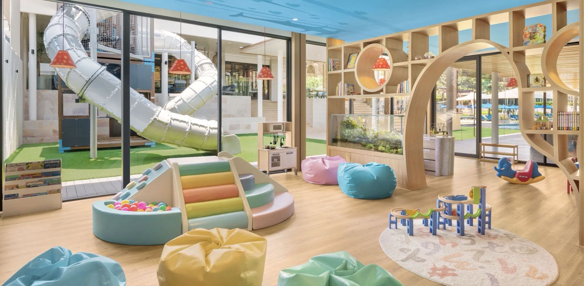 The kids' club, with a slide, cushions, and bright shelves