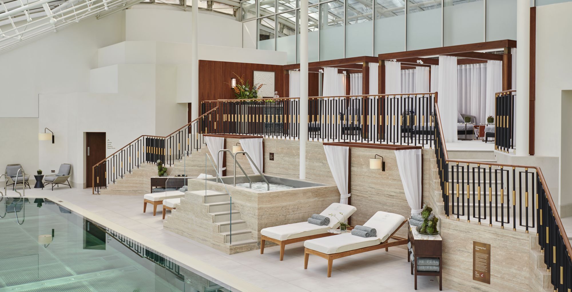 Loungers and cabanas beside the glass-roofed pool