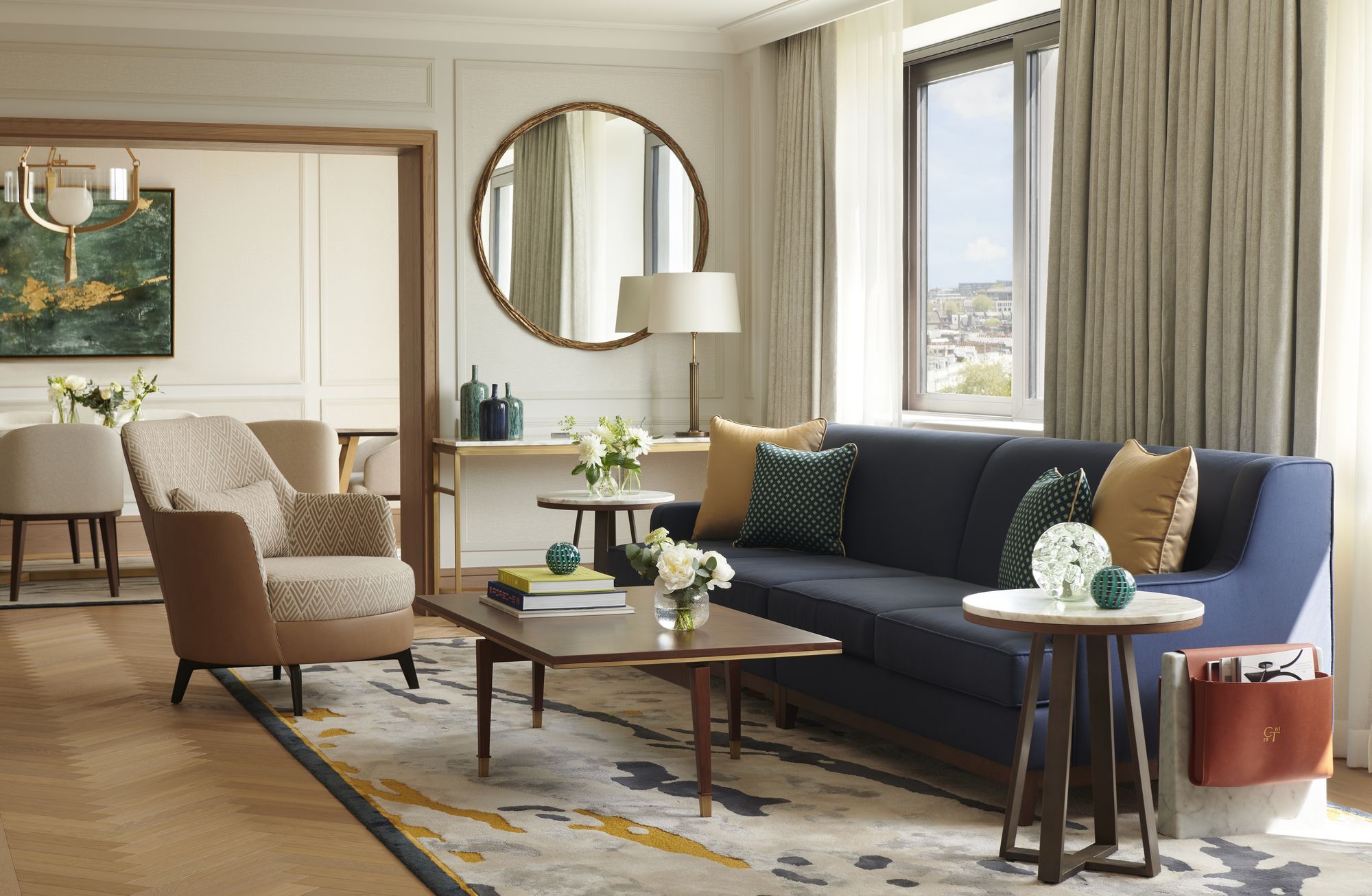 The Royal Suite's living and dining room, with a round mirror and city views
