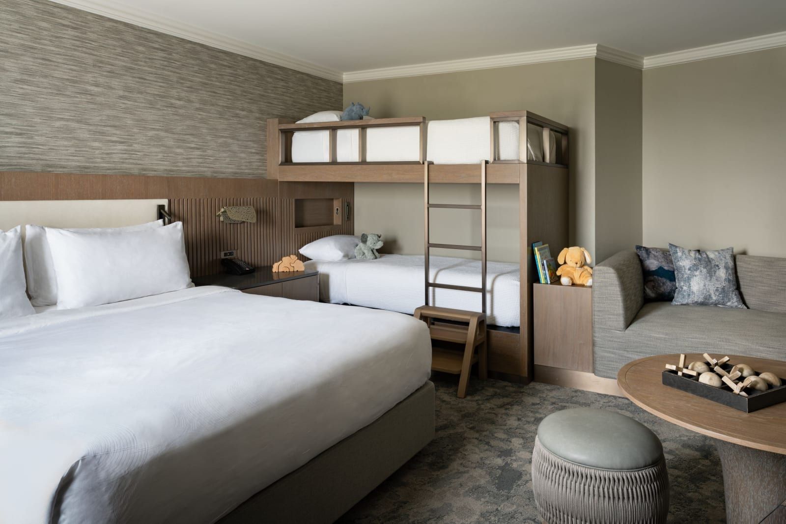 A family suite with a king bed and a set of bunk beds