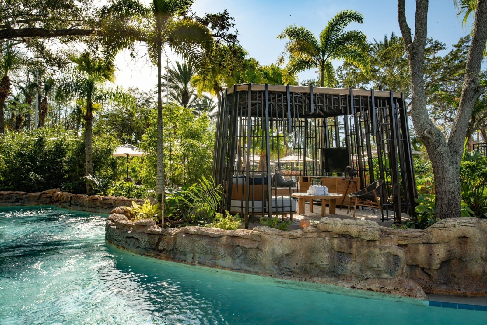 A private cabana beside the lazy river, framed by palms