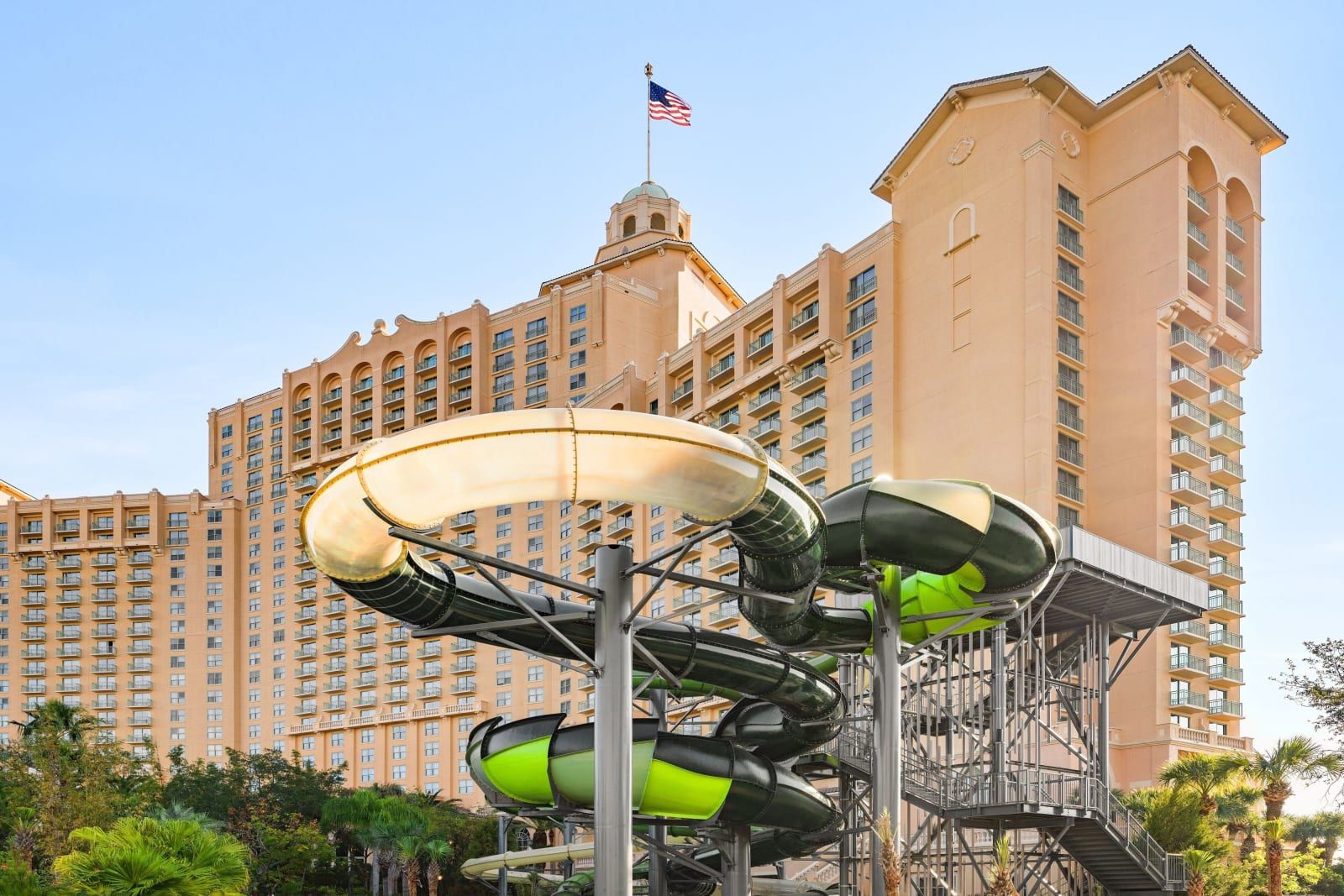 A green waterslide spiraling down beside the resort tower