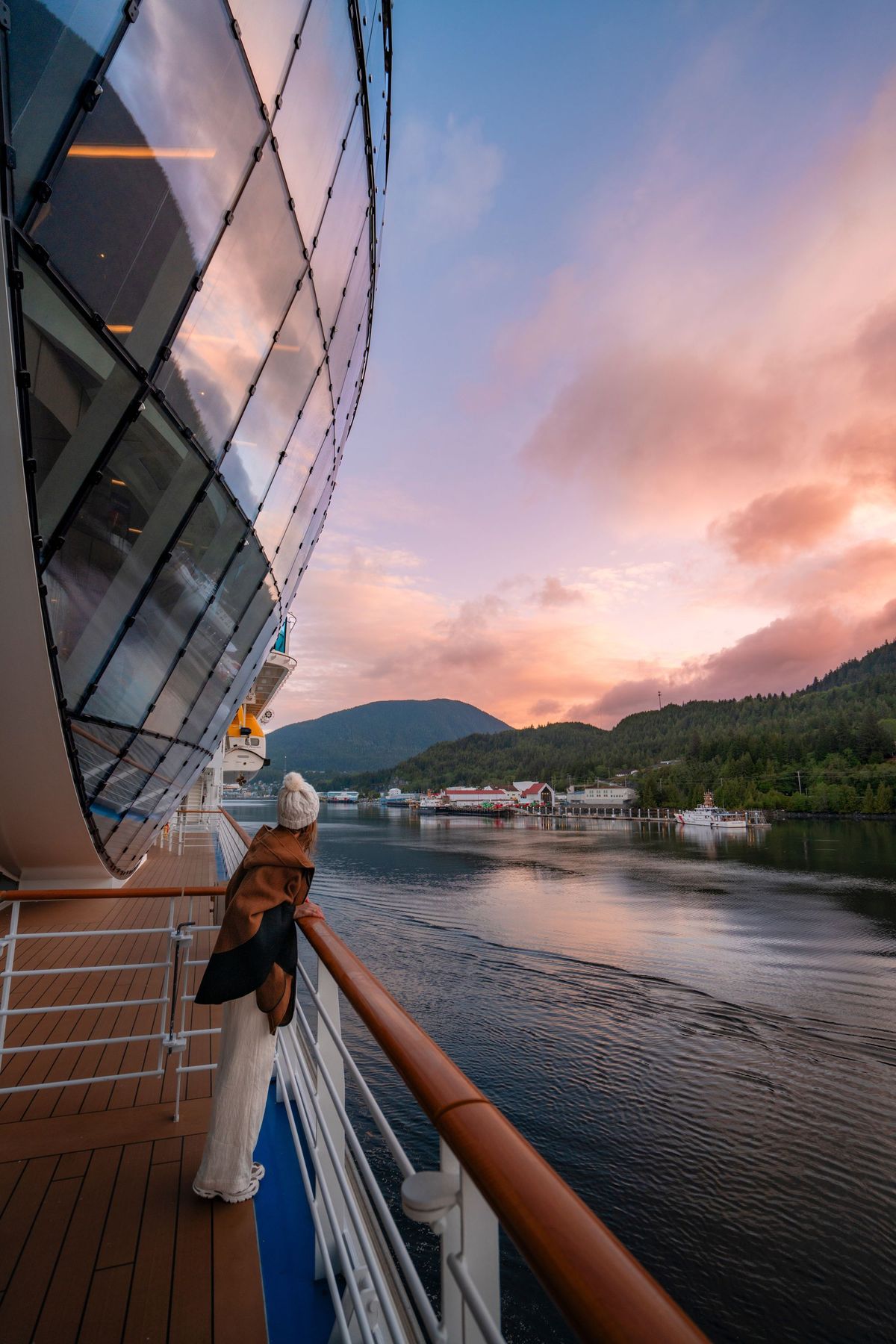A guest on a stateroom balcony at sunset near Ketchikan