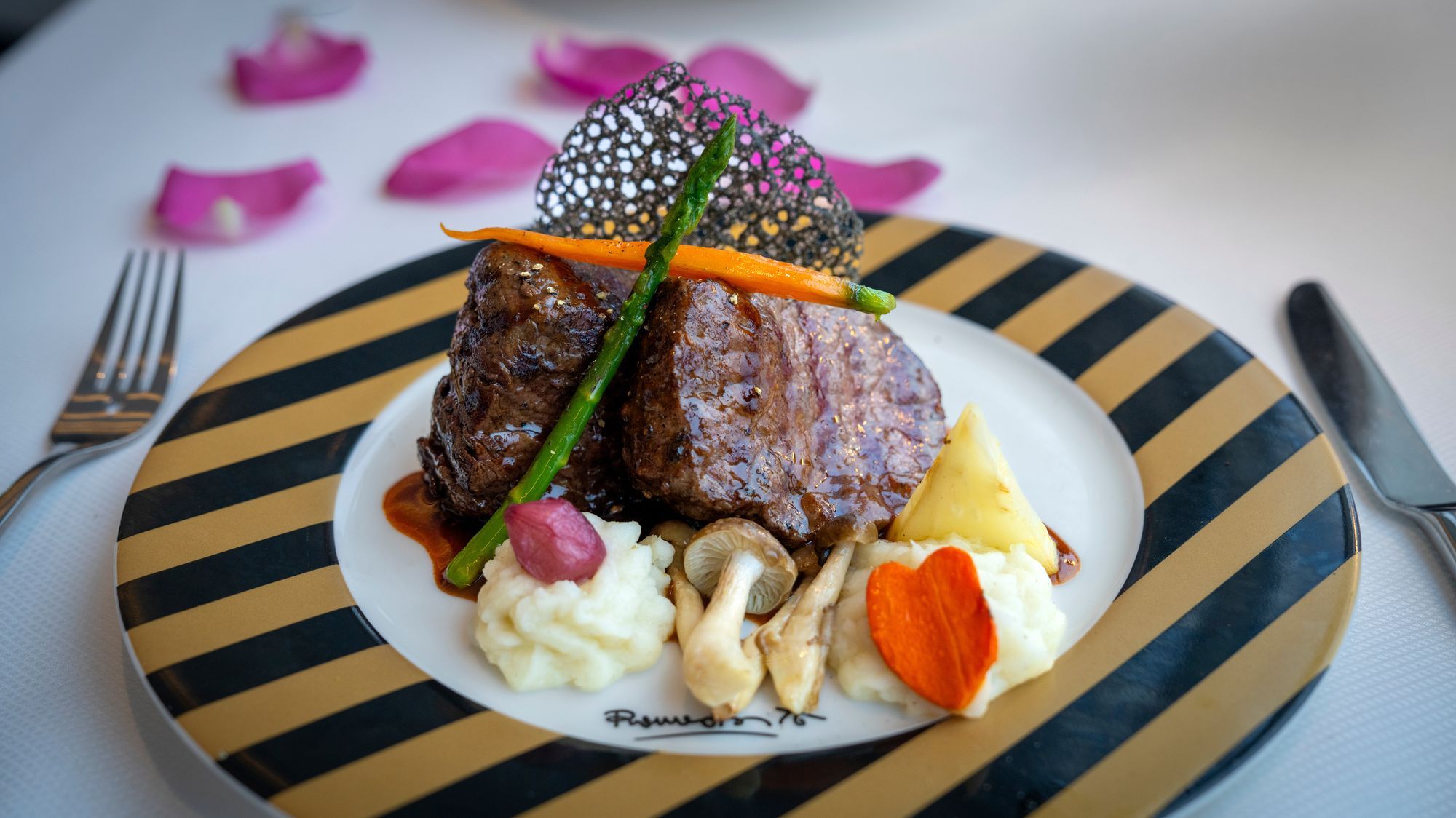 A plated steak dinner at Love by Britto