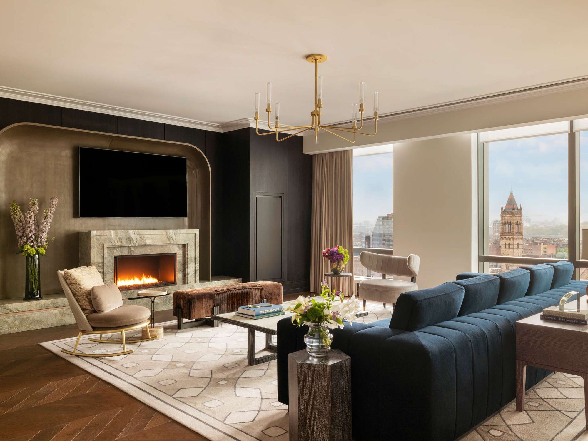 A suite living room with a fireplace and a view over Boston