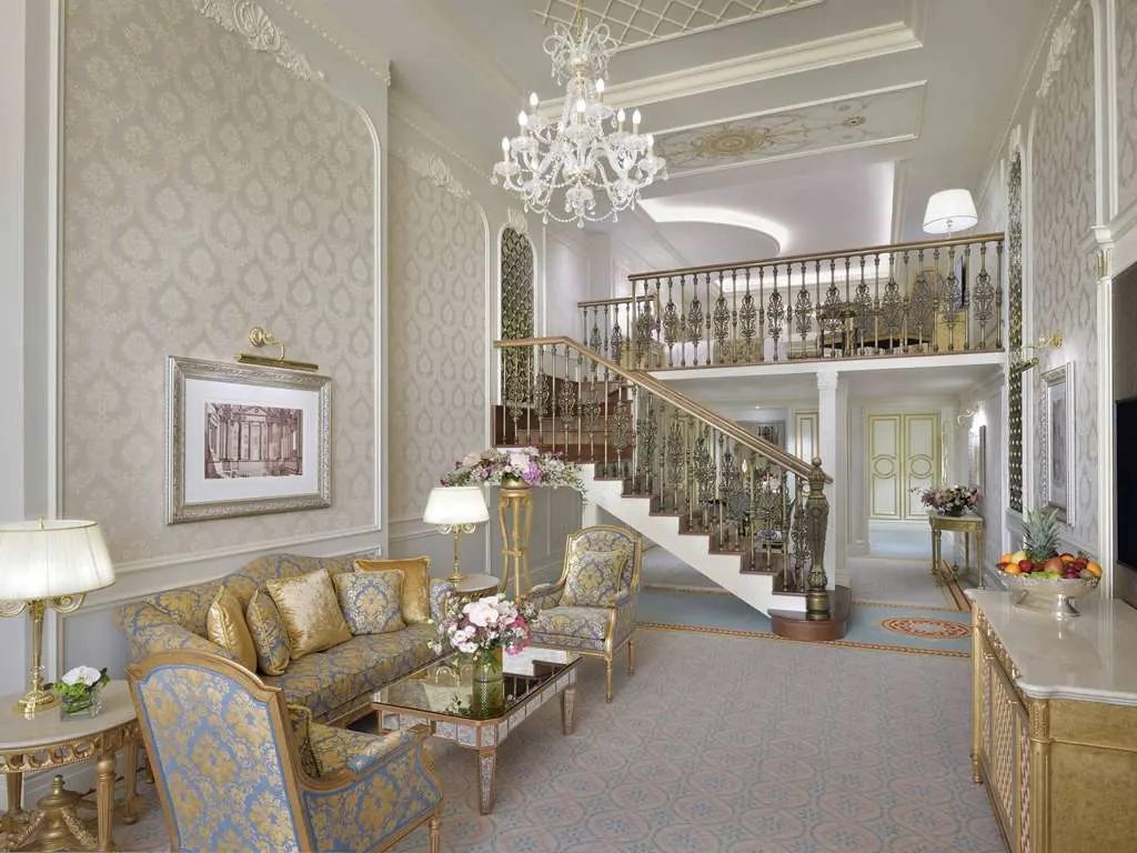 A two-level suite with a staircase rising to a gallery above the living room
