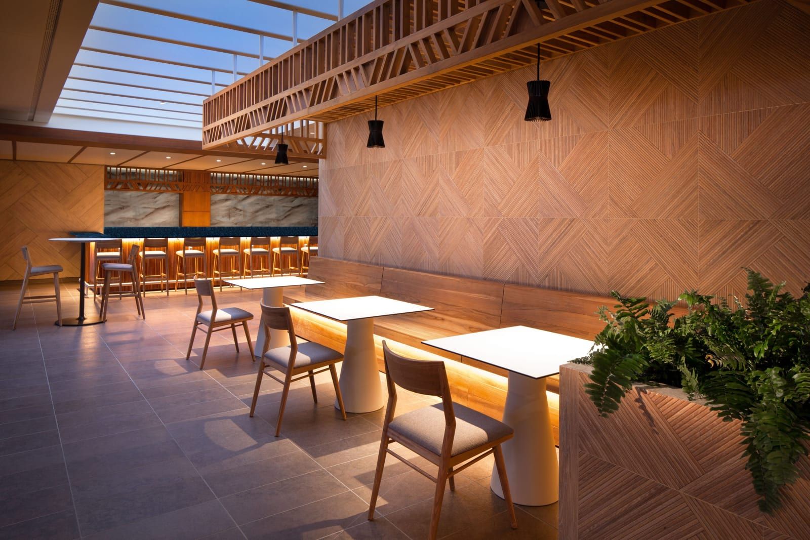 A warm-lit bar with high-top tables