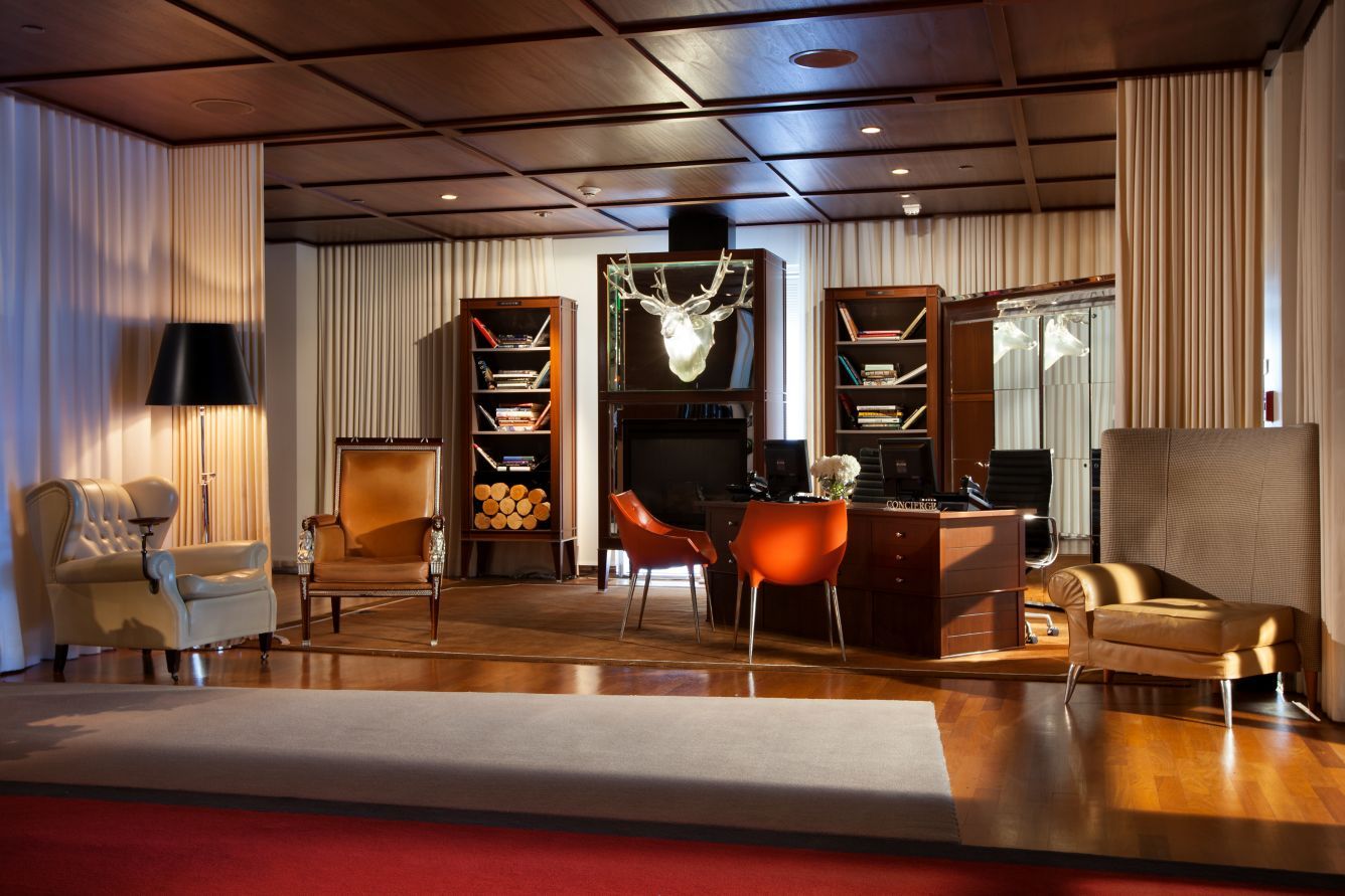 The concierge lounge, with a mounted stag head and wingback chairs