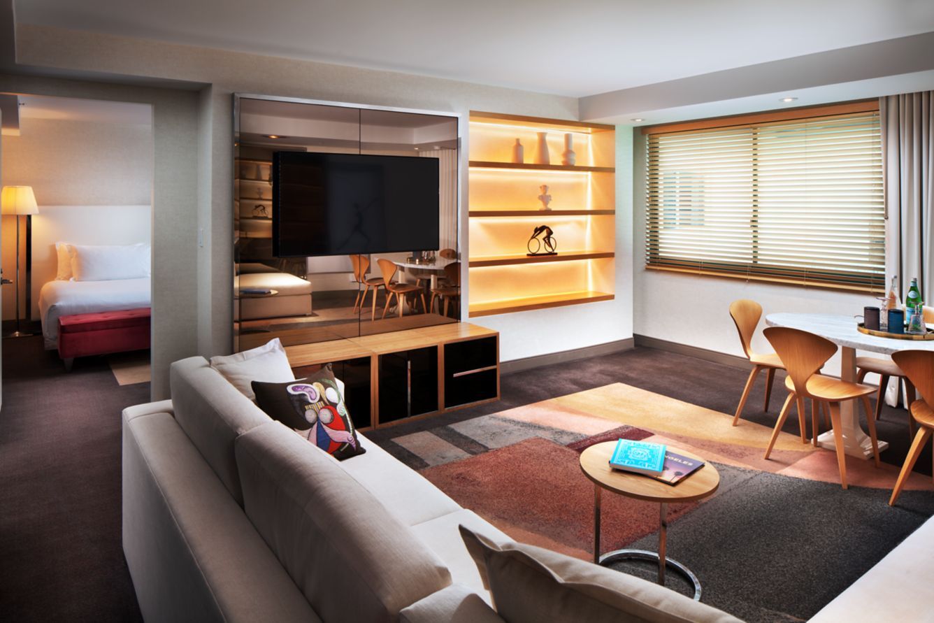 A deluxe suite living room with a sectional and dining table