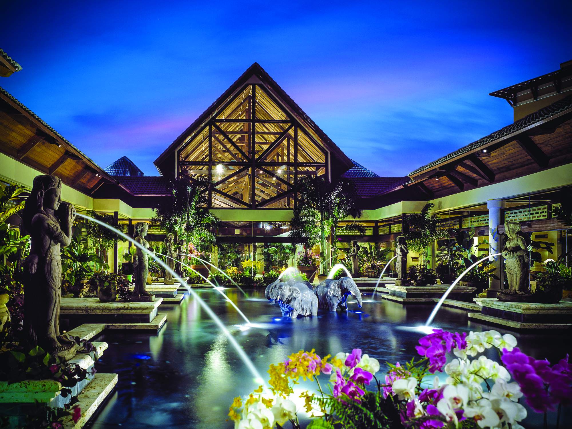 Orchid Court at Loews Royal Pacific Resort at night, with fountains and orchids